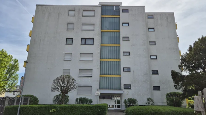 Wohnanlage mit grauer, fleckiger Fassade vor der Reinigung